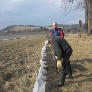 Stavba zábran, opatrenie ktoré znemožňuje obojživelníkom prechádzať cez cestu. Zachytené žabky následne prenášame cez cestu, aby sa bezpečne dostali na miesto rozmnožovania.